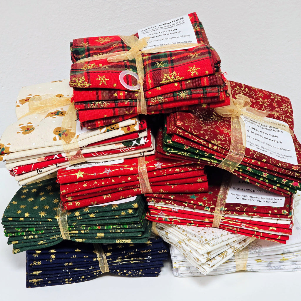 Stack of red, green, and white fabric bundles with gold accents on a light gray background