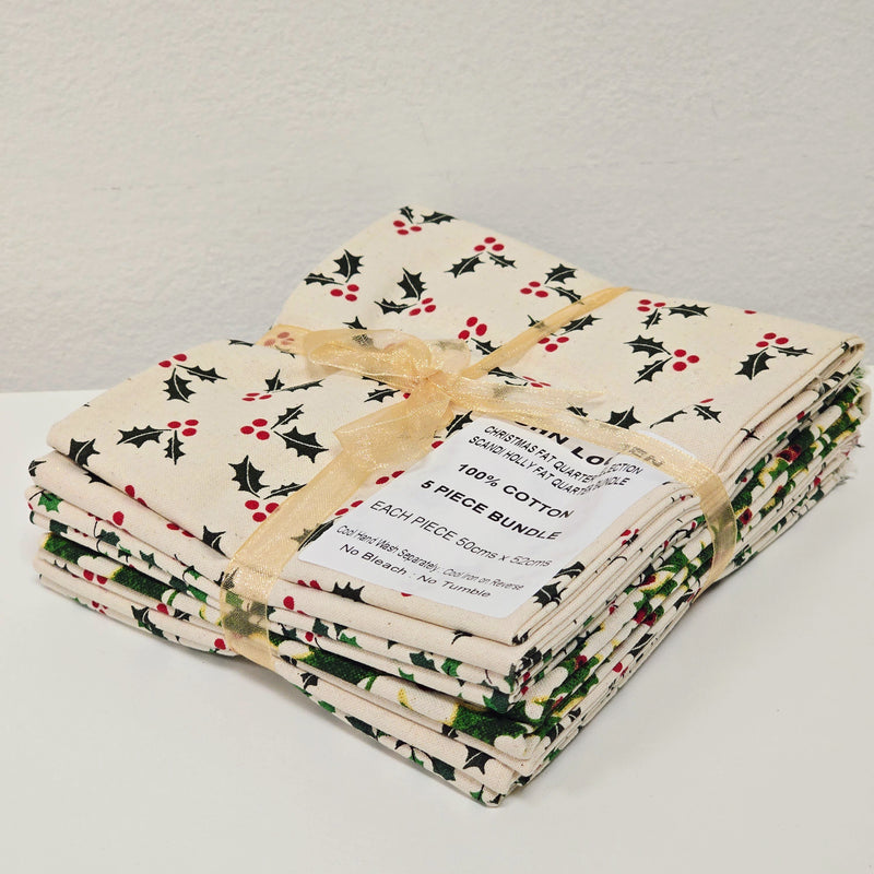 Stack of fabric bundles with holly leaf pattern on a light gray background