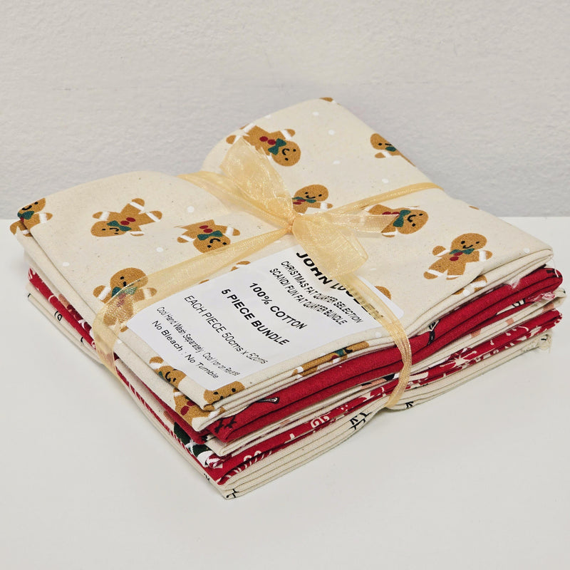 Stack of fabric bundles with gingerbread man patterns on a cream background