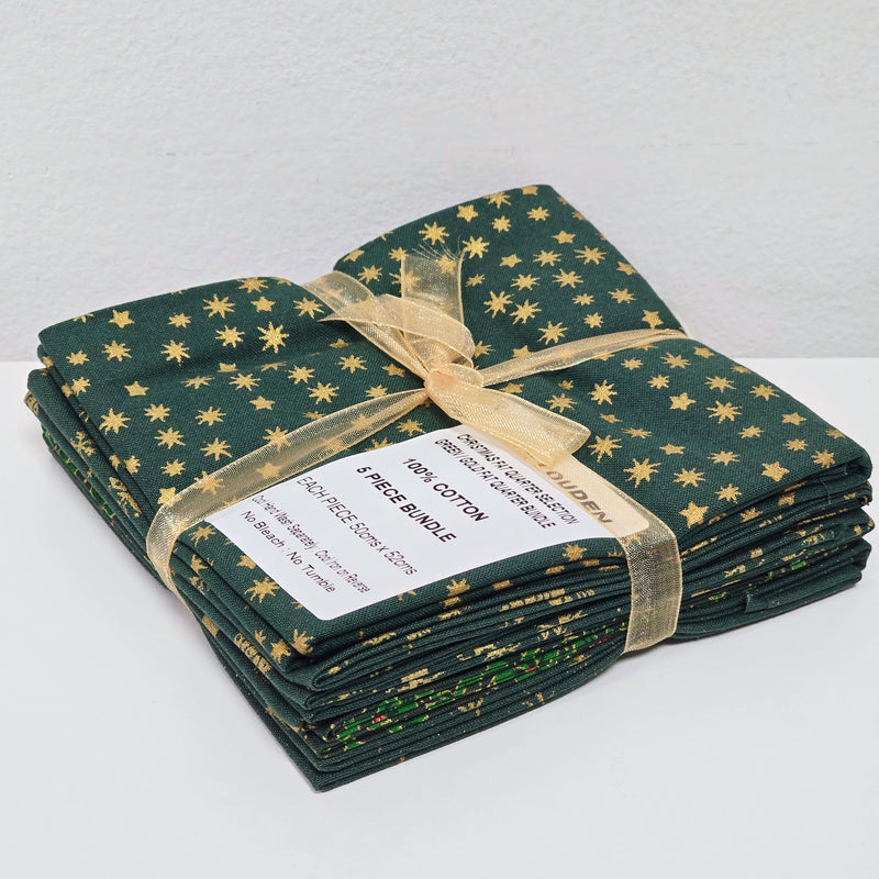 Stack of green fabric with gold star pattern tied with a gold ribbon on a white background
