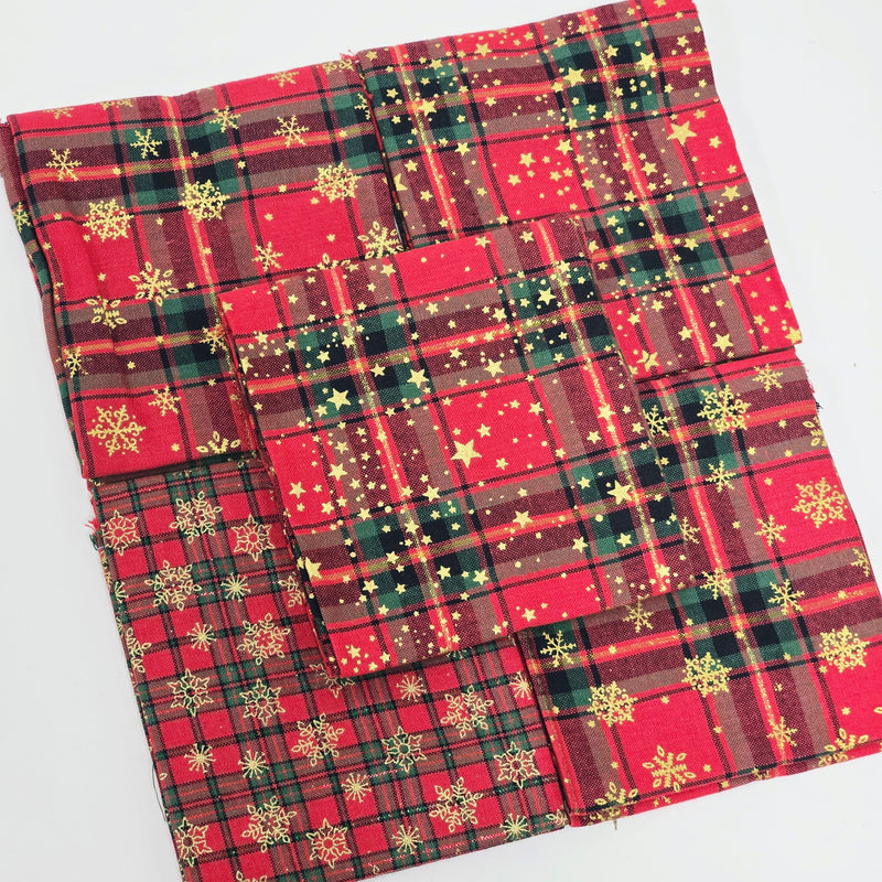 Red and green plaid fabric with snowflake patterns on a white background