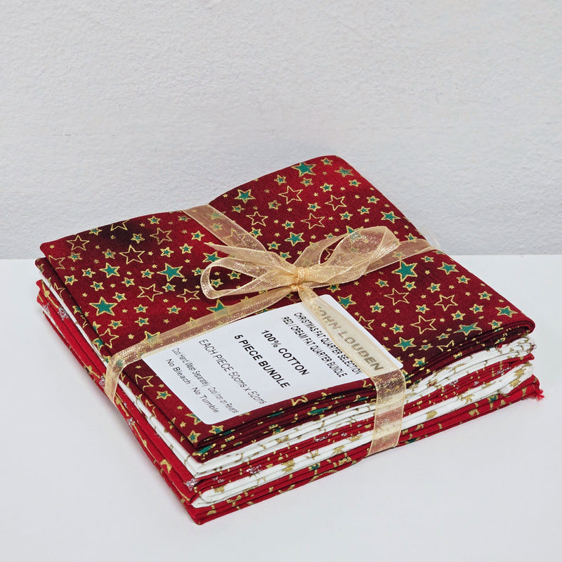 Stack of red fabric bundles with gold stars and a decorative bow on a white background