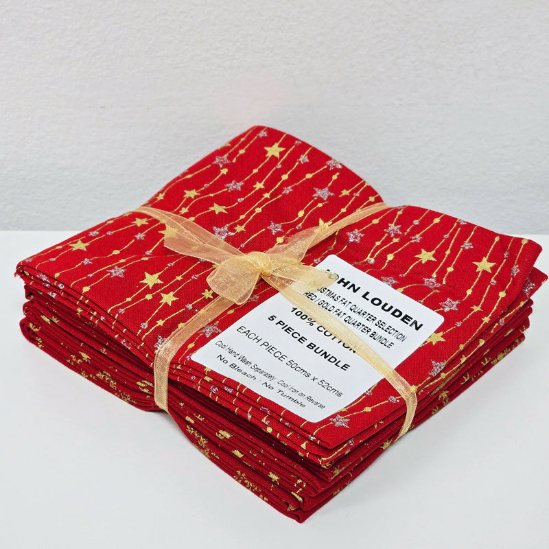 Stack of red fabric bundles with gold patterns and a label on a white background