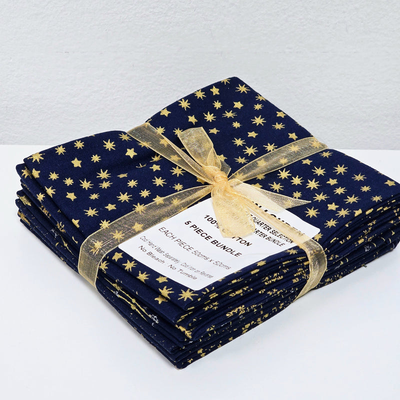 Folded navy fabric with gold star pattern and gold ribbon on a white background